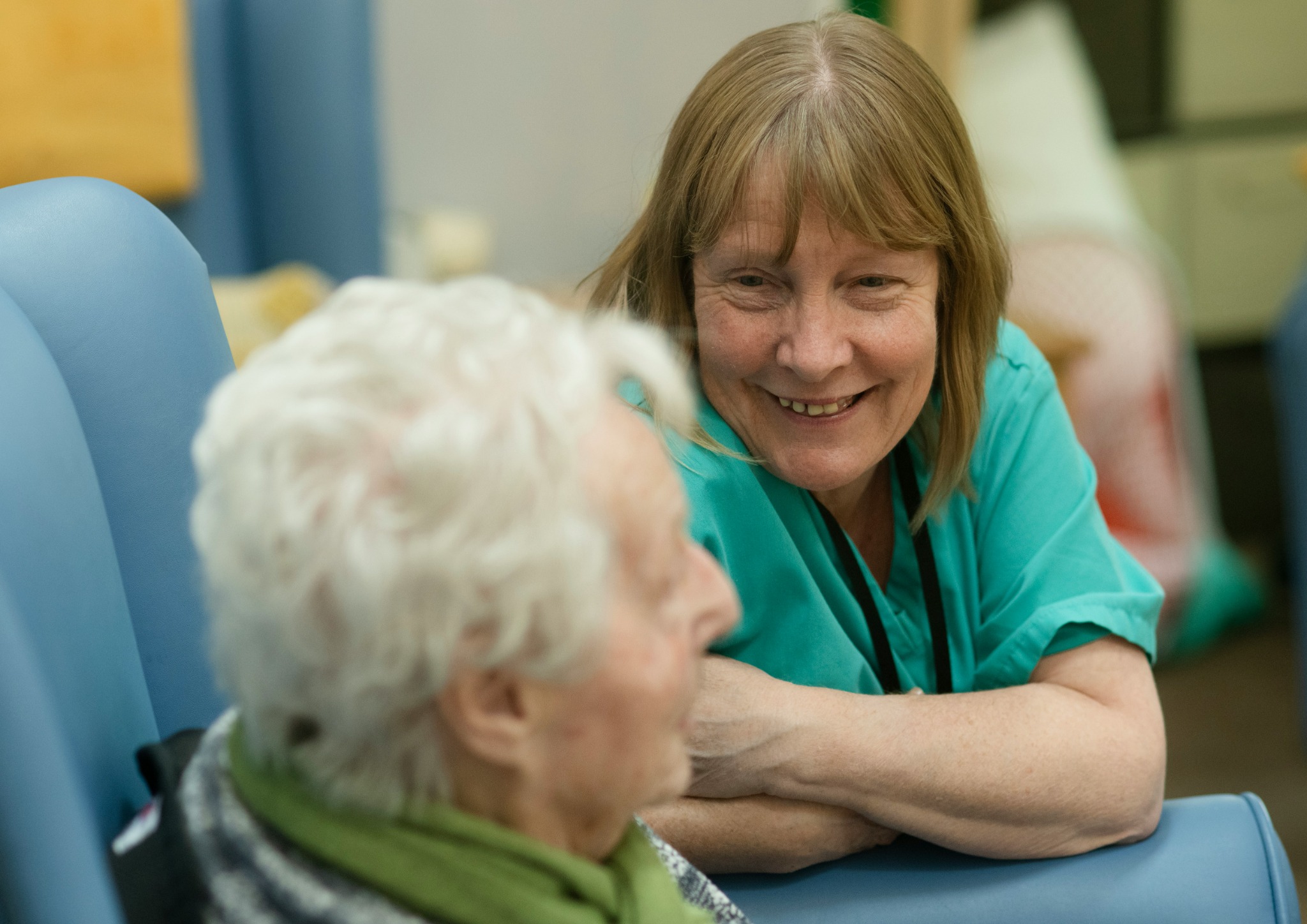Care worker talking with older adult in a lounge