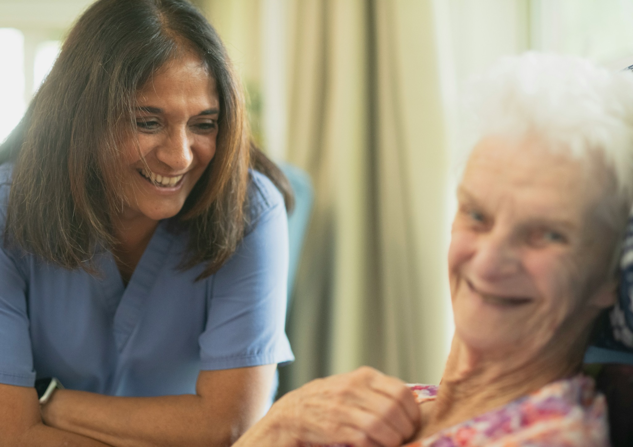 Caregiver smiling with an older adult